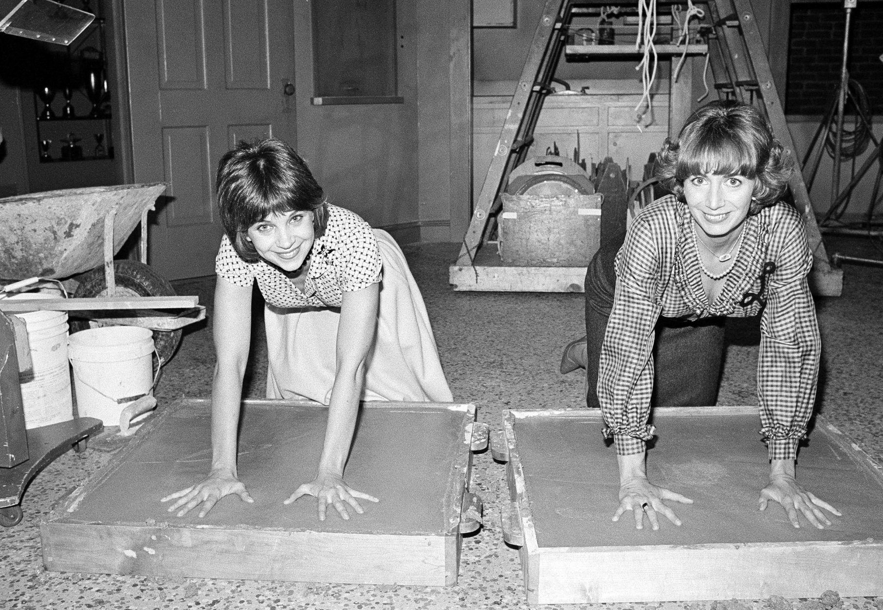 FILE - In this , Nov. 14, 1979, file photo taken by Associated Press photographer Lennox McLendon, shows actresses Cindy Williams, left, and Penny Marshall, stars of the ABC-TV comedy series "Laverne and Shirley," make an impression in cement after the taping of their show in Los Angeles. Lennox "Red" McLendon, a globe-trotting photographer who chronicled everything from the Vietnam War to the Academy Awards during a long career with the U.S. Navy and The Associated Press, has died at 74. McLendon died Oct. 24, 2017 in Las Vegas, according to his family. (AP Photo/Lennox McLendon, File)