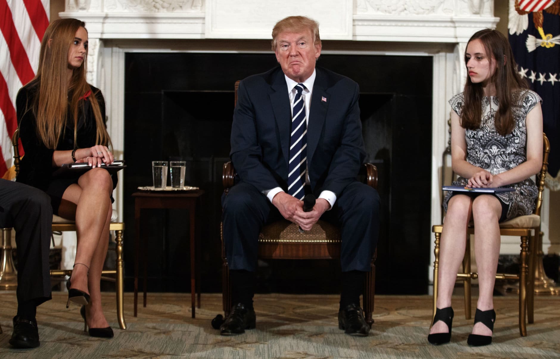 President Donald Trump, joined by Marjory Stoneman Douglas High School student Carson Abt, right, and Julia Cordover, the school's student body president, pauses during a listening session with high school students, teachers and others at the White House in Washington on Feb. 21, 2018, a week after a gunman massacred 17 people at the Florida high school. (AP Photo/Carolyn Kaster)