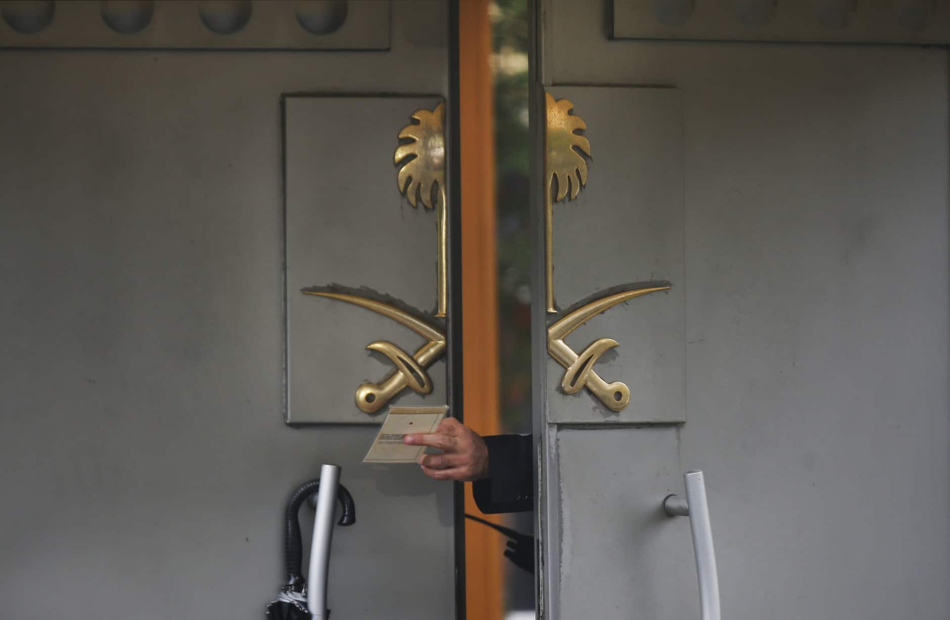 A security guard passes a document to a colleague outside Saudi Arabia's Consulate in Istanbul on Oct. 15, 2018, nearly two weeks after Saudi journalist Jamal Khashoggi was killed at the consulate. (AP Photo/Petros Giannakouris)
