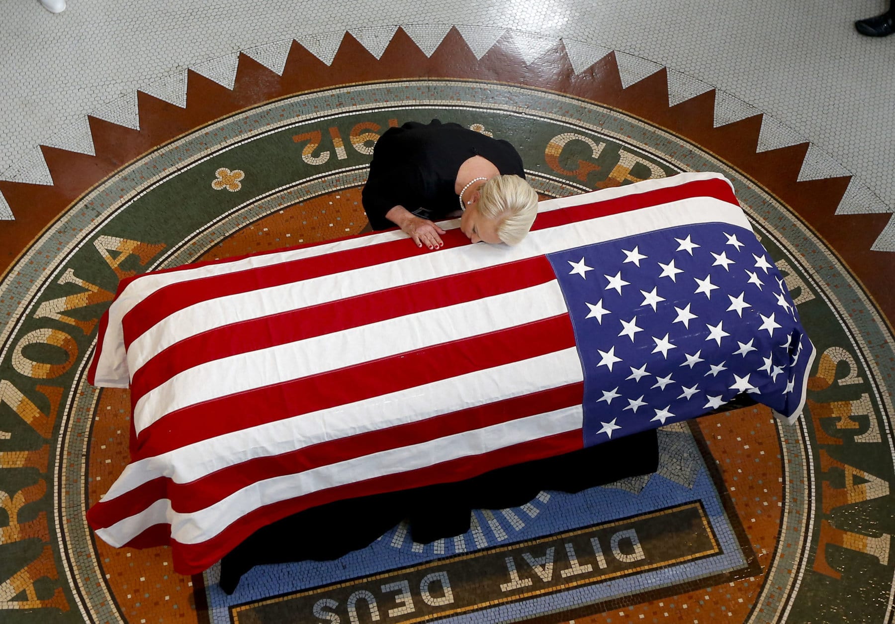 Cindy McCain, wife of Sen. John McCain, R-Ariz., rests her head on his casket during a memorial service at the Arizona Capitol in Phoenix on Aug. 29, 2018. (AP Photo/Ross D. Franklin)