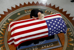 Cindy McCain, wife of Sen. John McCain, R-Ariz., rests her head on his casket during a memorial service at the Arizona Capitol in Phoenix on Aug. 29, 2018. (AP Photo/Ross D. Franklin)