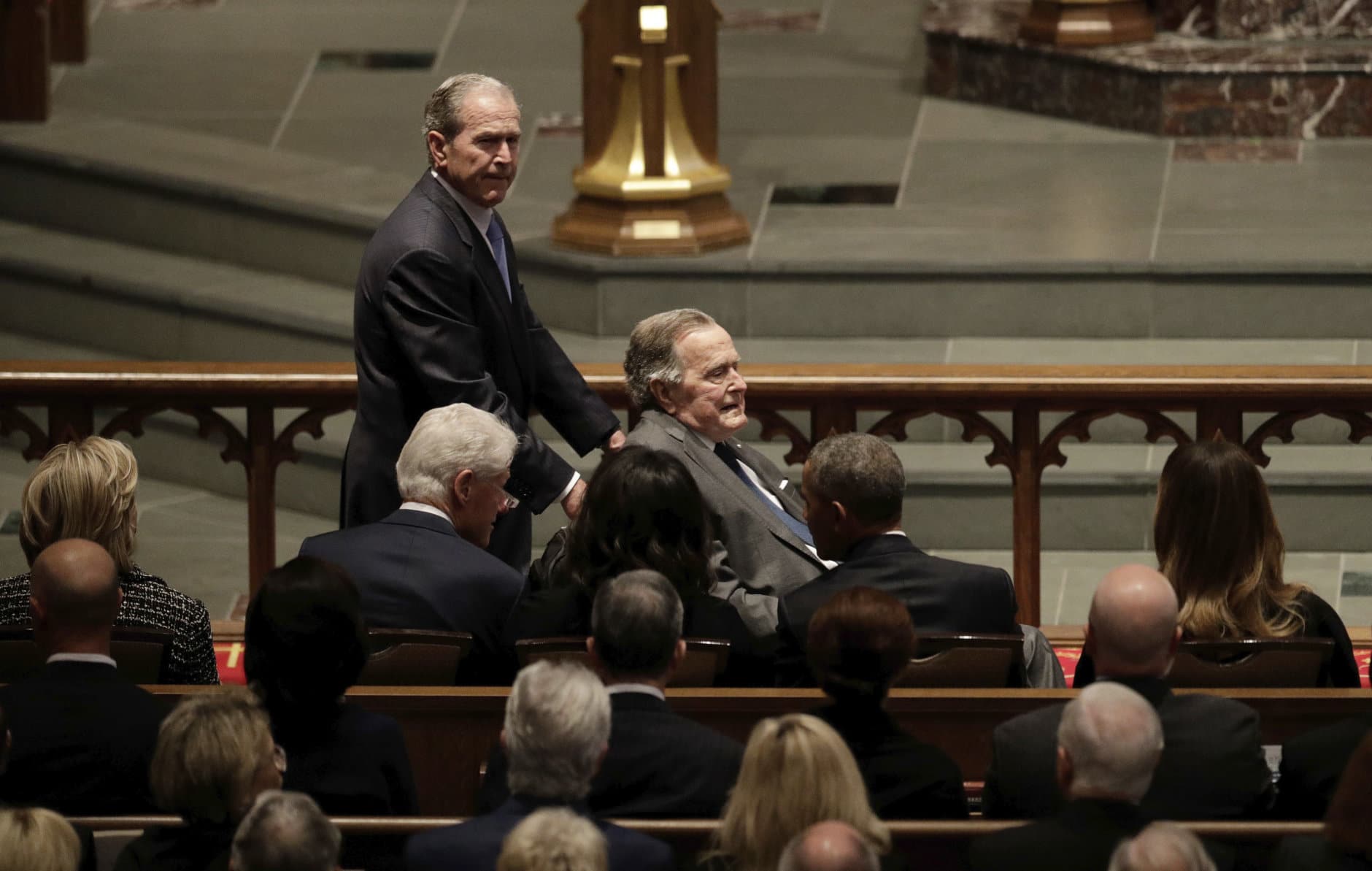 Former Presidents George W. Bush and George H.W. Bush arrive at St. Martin's Episcopal Church in Houston for the funeral for former first lady Barbara Bush on April 21, 2018. Seated in the front row, from left, are former first lady Hillary Clinton, former President Bill Clinton, former first lady Michelle Obama, former President Barack Obama and first lady Melania Trump. (AP Photo/David J. Phillip)