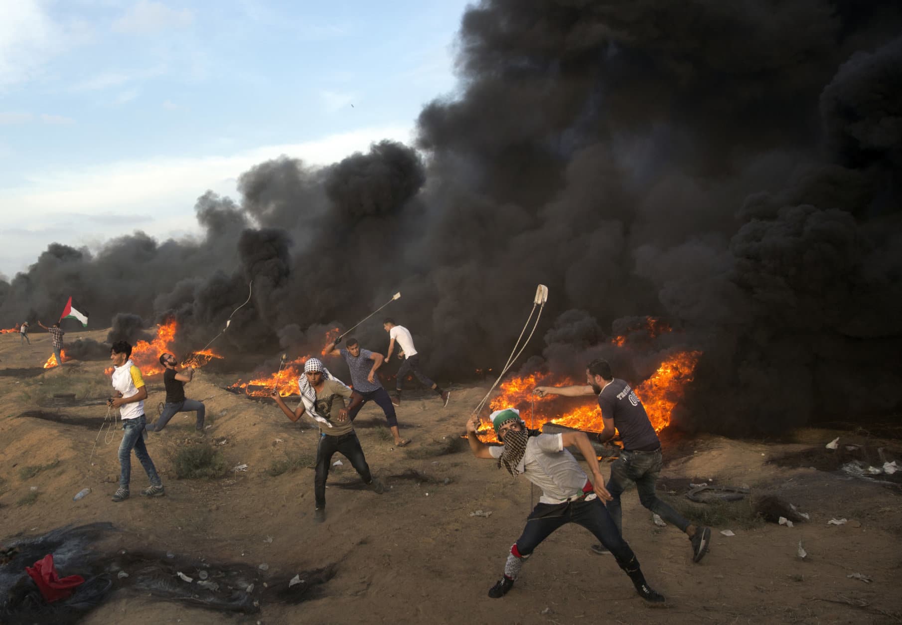 Palestinians hurl stones during a protest at the Gaza Strip's border with Israel on Oct. 5, 2018. (AP Photo/Khalil Hamra)