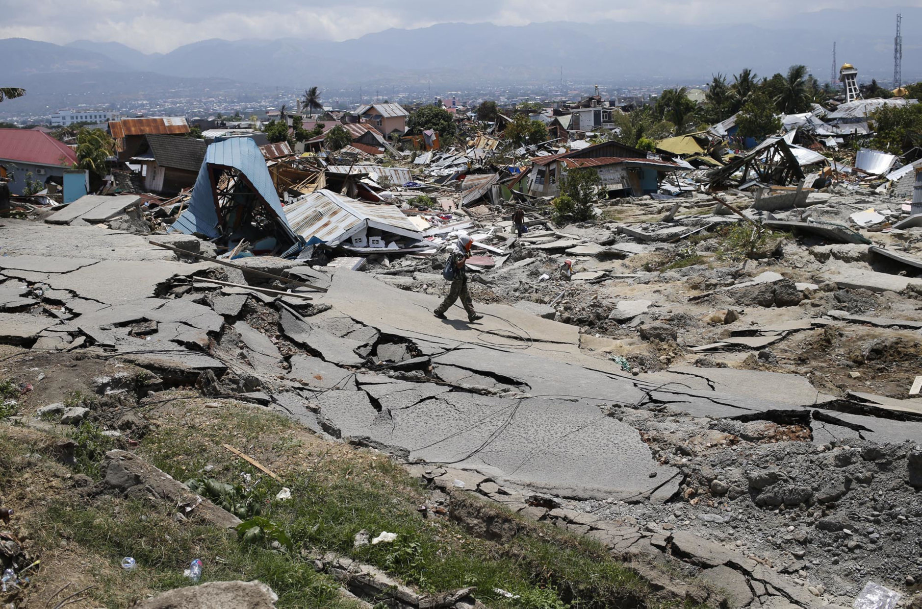 A man walks through the Balaroa neighborhood in Palu, Central Sulawesi, Indonesia, on Oct. 2, 2018, four days after a massive earthquake struck the region. (AP Photo/Dita Alangkara)