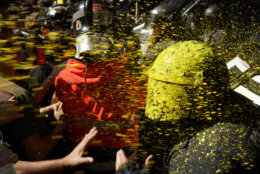 Pro independence demonstrators throw paint at Catalan police officers during clashes in Barcelona, Spain, on Sept. 29, 2018, as tensions increase before the anniversary of the Spanish region's illegal referendum on secession that ended in violent raids by security forces. (AP Photo/Daniel Cole)