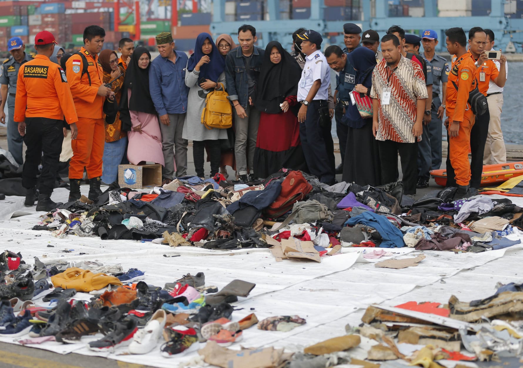 Relatives of passengers on the crashed Lion Air jet check personal belongings retrieved from the waters where the airplane is believed to have crashed, at Tanjung Priok Port in Jakarta, Indonesia, on Oct. 31, 2018. (AP Photo/Tatan Syuflana)
