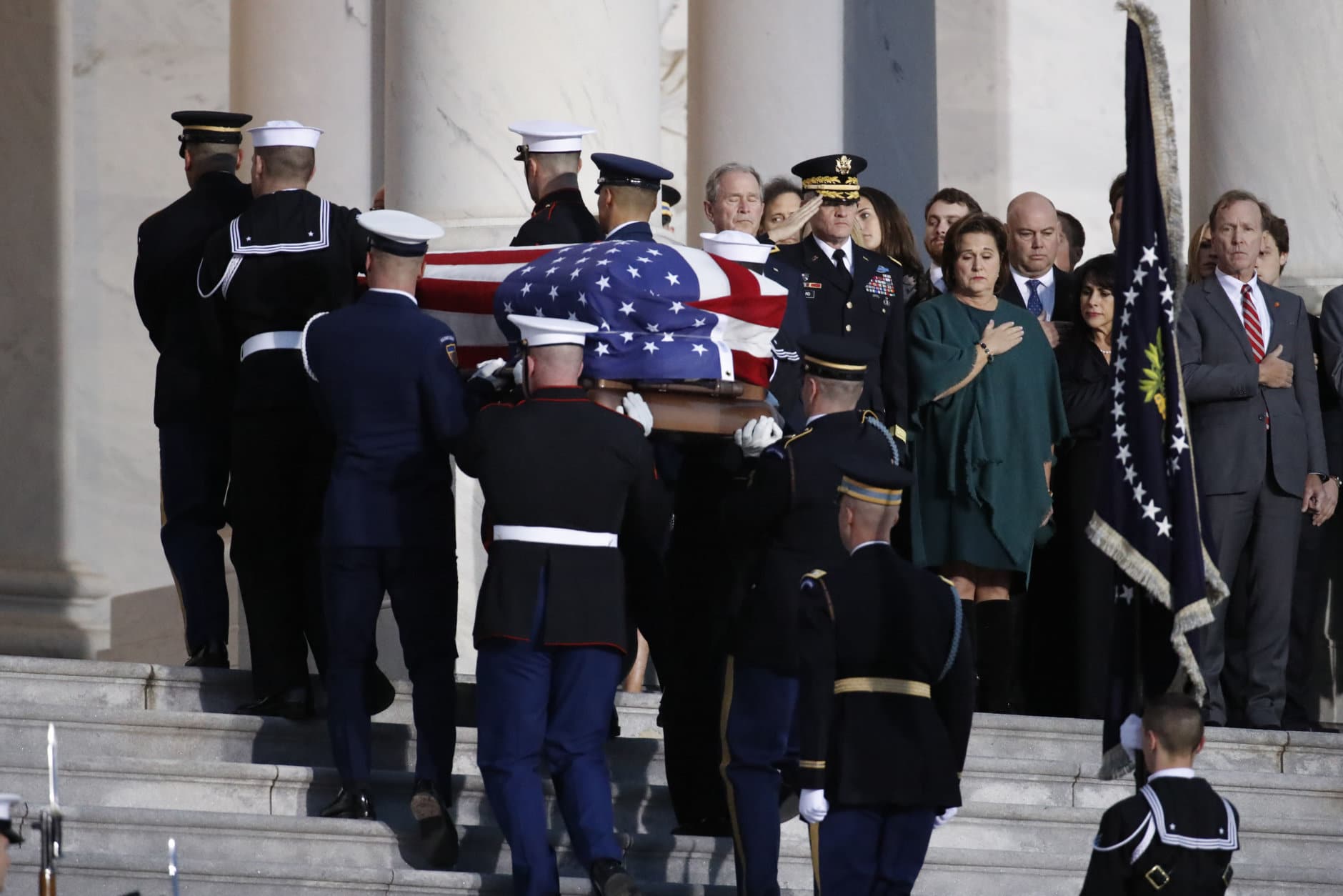 The flag-draped casket of former President George H.W. Bush is carried by a joint services military honor guard to lie in state in the rotunda of the U.S. Capitol, Monday, Dec. 3, 2018, in Washington. (AP Photo/Alex Brandon, Pool)