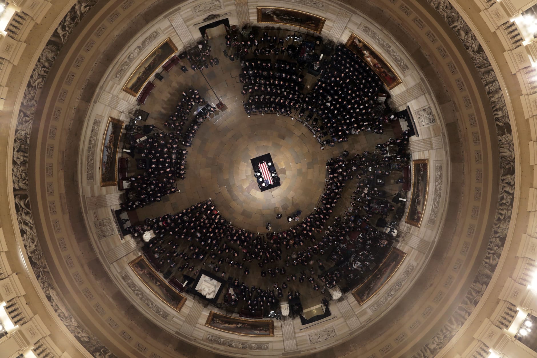 The flag-draped casket of former President George H.W. Bush is placed by a joint services military honor guard into the U.S. Capitol Rotunda Monday, Dec. 3, 2018, in Washington. (Pool photo by Morry Gash via AP)