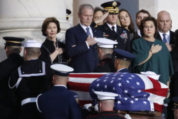 Former President George W. Bush and other family members watch as the flag-draped of former President George H.W. Bush is carried by a joint services military honor guard to lie in state in the rotunda of the U.S. Capitol, Monday, Dec. 3, 2018, in Washington.(AP Photo/Alex Brandon, Pool)