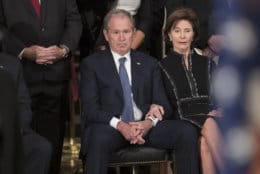 Former President George W. Bush, sits with former first lady Laura Bush, during ceremonies for his father, former President George H.W. Bush, as he lies in state at the Capitol Rotunda where in Washington, Monday, Dec. 3, 2018. (AP Photo/J. Scott Applewhite)