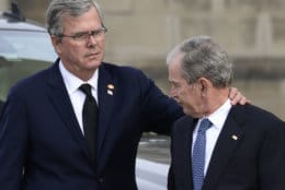 Former Florida Gov. Jeb Bush, left, reaches out to his brother, former President George W. Bush, right, as they arrive to watch the casket of former President George H.W. Bush arrive at the National Cathedral, Wednesday, Dec. 5, 2018, in Washington, for a State Funeral. (AP Photo/Susan Walsh)