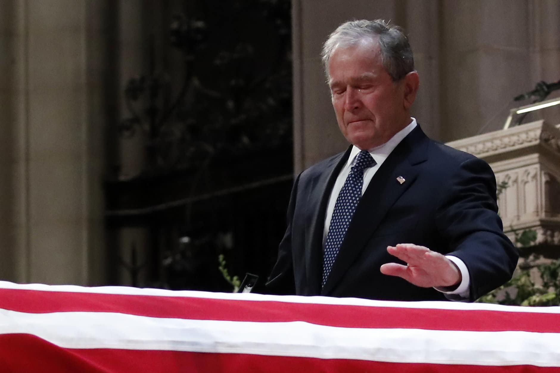 Former President George W. Bush touches the casket of his father, former President George H.W. Bush, at the State Funeral at the National Cathedral, Wednesday, Dec. 5, 2018, in Washington.(AP Photo/Alex Brandon, Pool)