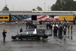 The flag-draped casket of former President George H.W. Bush is carried by a joint services military honor guard to a train at Union Pacific Westfield auto facility Thursday, Dec. 6, 2018, in Spring, Texas. (AP Photo/Kiichiro Sato)