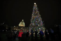 People gather around the U.S. Capitol Christmas Tree during the lighting ceremony at the West Front of the U.S. Capitol in Washington, Thursday, Dec. 6, 2018. The 80-foot Noble Fir was harvested from the Willamette National Forest in Oregon. (AP Photo/Manuel Balce Ceneta)