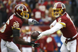 Washington Redskins running back Adrian Peterson (26) takes the hand off from quarterback Mark Sanchez (6) during the first half of an NFL football game New York Giants, Sunday, Dec. 9, 2018, in Landover, Md. (AP Photo/Patrick Semansky)