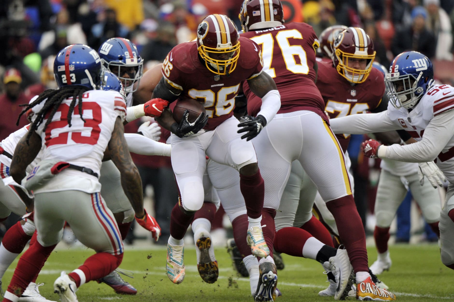 Washington Redskins running back Adrian Peterson (26) breaks through the line as New York Giants cornerback B.W. Webb (23) moves in, during the first half of an NFL football game Sunday, Dec. 9, 2018, in Landover, Md. (AP Photo/Mark Tenally)