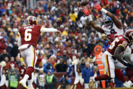 New York Giants outside linebacker Kareem Martin, right, tips a pass by Washington Redskins quarterback Mark Sanchez (6) enabling New York Giants free safety Curtis Riley to intercept the pass and return it for a touchdown, during the first half of an NFL football game Sunday, Dec. 9, 2018, in Landover, Md. (AP Photo/Patrick Semansky)