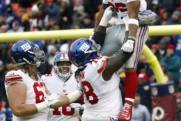 New York Giants running back Saquon Barkley (26) is picked up offensive guard Jamon Brown (78) as they celebrate his 78-yard touchdown during the first half of an NFL football game against the Washington Redskins, Sunday, Dec. 9, 2018, in Landover, Md. (AP Photo/Patrick Semansky)