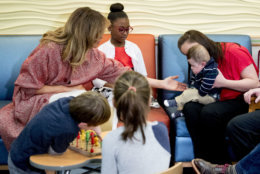 First lady Melania Trump, greets children released from the neonatal intensive care unit (NICU) and their parents at Children's National Health System, Thursday, Dec. 13, 2018, in Washington. (AP Photo/Andrew Harnik)