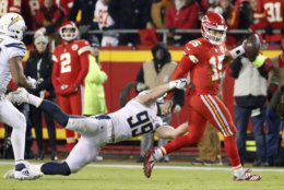 Kansas City Chiefs quarterback Patrick Mahomes (15) runs past a tackle attempt by Los Angeles Chargers defensive end Joey Bosa (99) during the second half of an NFL football game in Kansas City, Mo., Thursday, Dec. 13, 2018. (AP Photo/Charlie Riedel)