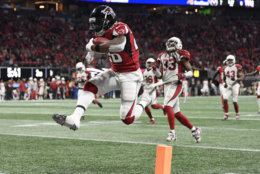 Atlanta Falcons running back Tevin Coleman (26) leaps into the end zone as he scores on a pass from Matt Ryan during the second half of an NFL football game against the Arizona Cardinals, Sunday, Dec. 16, 2018, in Atlanta. (AP Photo/Danny Karnik)