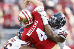 San Francisco 49ers quarterback Nick Mullens (4) is hit by Chicago Bears defensive end Akiem Hicks, left, and outside linebacker Khalil Mack during the second half of an NFL football game in Santa Clara, Calif., Sunday, Dec. 23, 2018. (AP Photo/D. Ross Cameron)