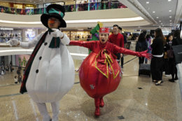Promoters dressed as Christmas characters perform at a shopping mall as the territory prepares to celebrate the Christmas holidays, in Hong Kong Monday, Dec. 24, 2018. (AP Photo/Vincent Yu)
