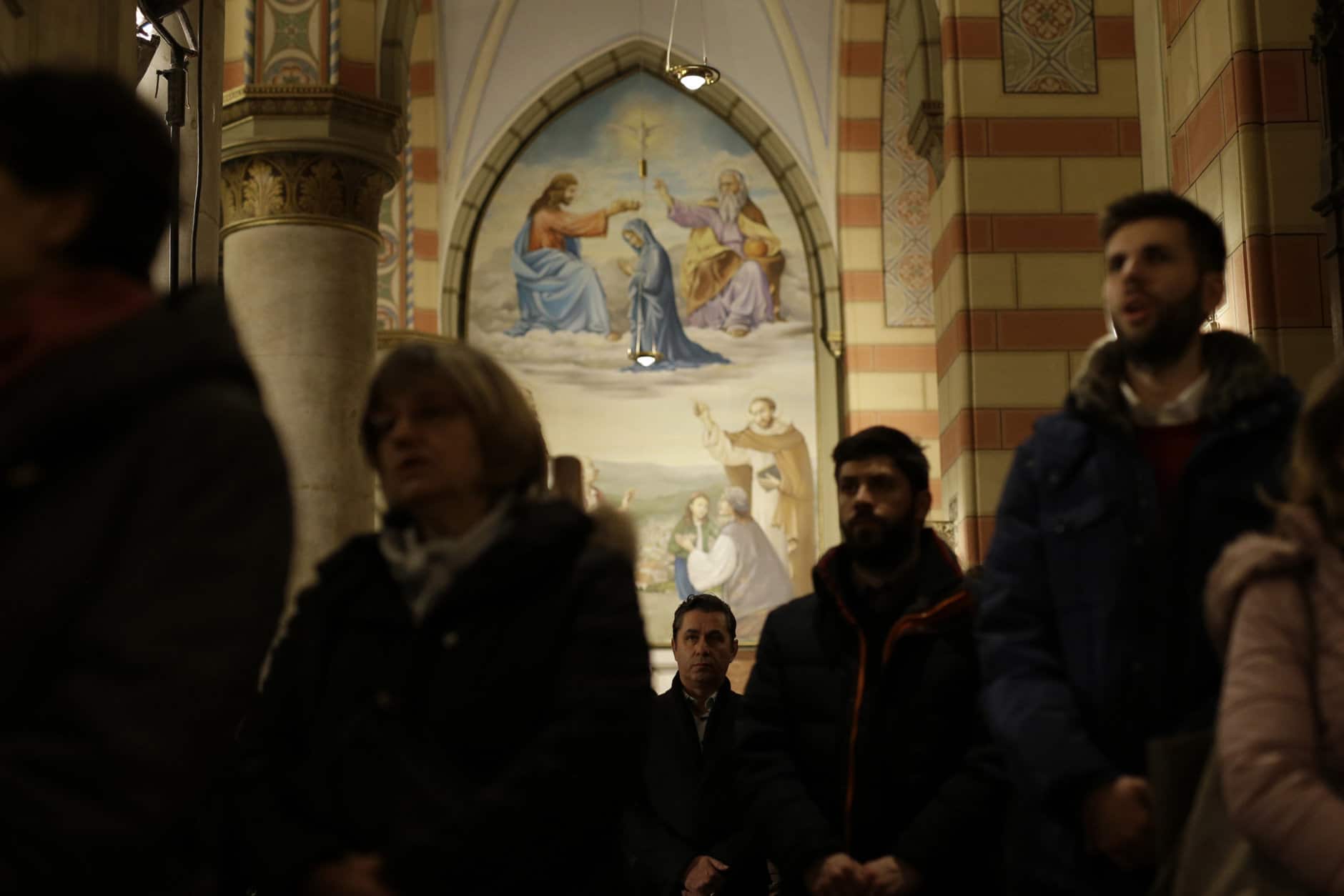 Bosnian people offer a prayer during the Christmas midnight mass in Sarajevo main Cathedral, in Sarajevo, Bosnia, on Tuesday, Dec. 25, 2018. Roman Catholics around the world celebrate Christmas today according to the Gregorian calendar.(AP Photo/Amel Emric)