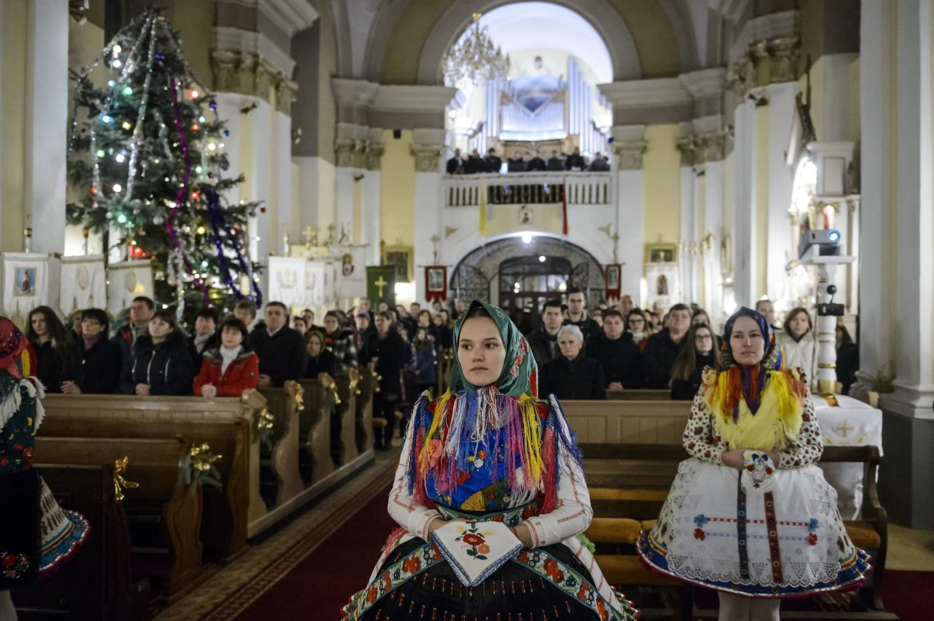 In this Dec. 24, 2018 photo faithful in folk costumes attend the Midnight Mass on Christmas Eve in Saint Martin of Tours' Church in the village of Bujak, 84 kms northeast of Budapest, Hungary. (Peter Komka/MTI via AP)