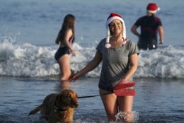 A woman and her dog take part in the traditional Boxing Day swim at Tynemouth beach in north east England, Wednesday Dec. 26, 2018. (Owen Humphreys/PA via AP)
