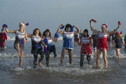 Revellers in cheerleader costumes take part in the traditional Boxing Day swim at Tynemouth beach in north east England, Wednesday Dec. 26, 2018. (Owen Humphreys/PA via AP)