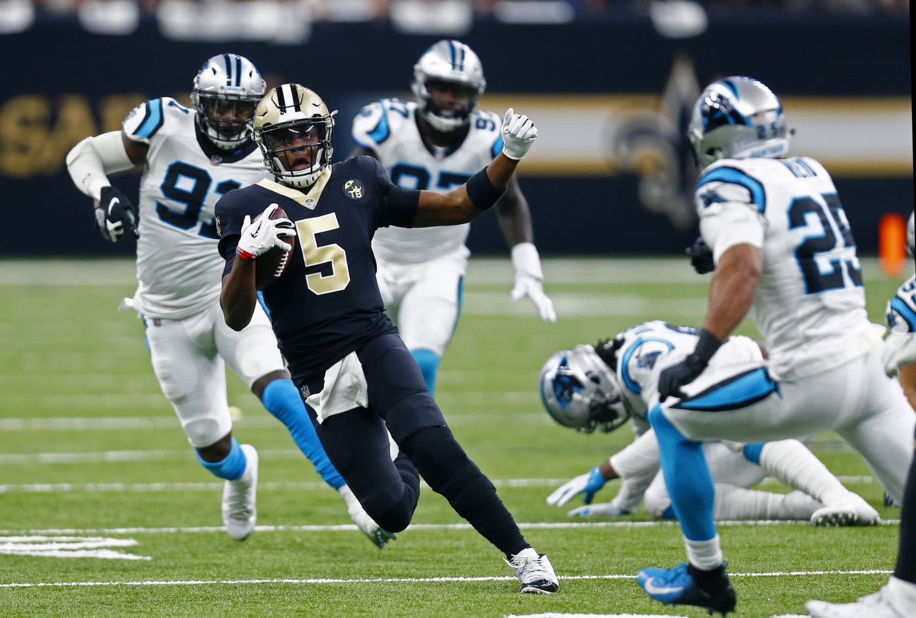 New Orleans Saints quarterback Teddy Bridgewater (5) goes to slide on a carry between Carolina Panthers strong safety Eric Reid (25) and defensive end Bryan Cox (91) in the first half of an NFL football game in New Orleans, Sunday, Dec. 30, 2018. (AP Photo/Butch Dill)