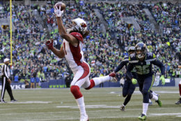 Arizona Cardinals' Larry Fitzgerald, left, snags a one-handed touchdown pass against the Seattle Seahawks during the first half of an NFL football game, Sunday, Dec. 30, 2018, in Seattle. (AP Photo/John Froschauer)