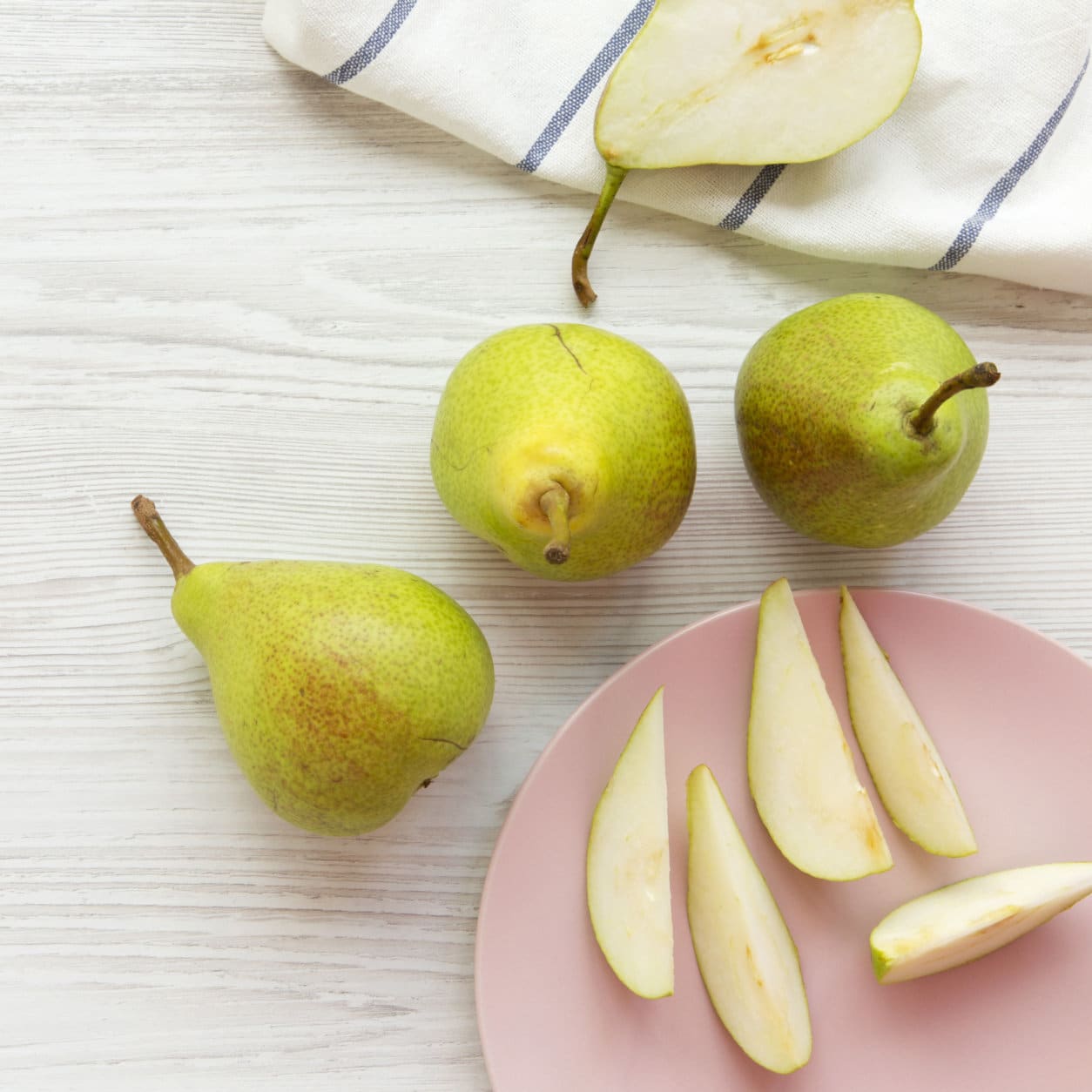 Fresh pears on white wooden background. From above, overhead view, flat lay.
