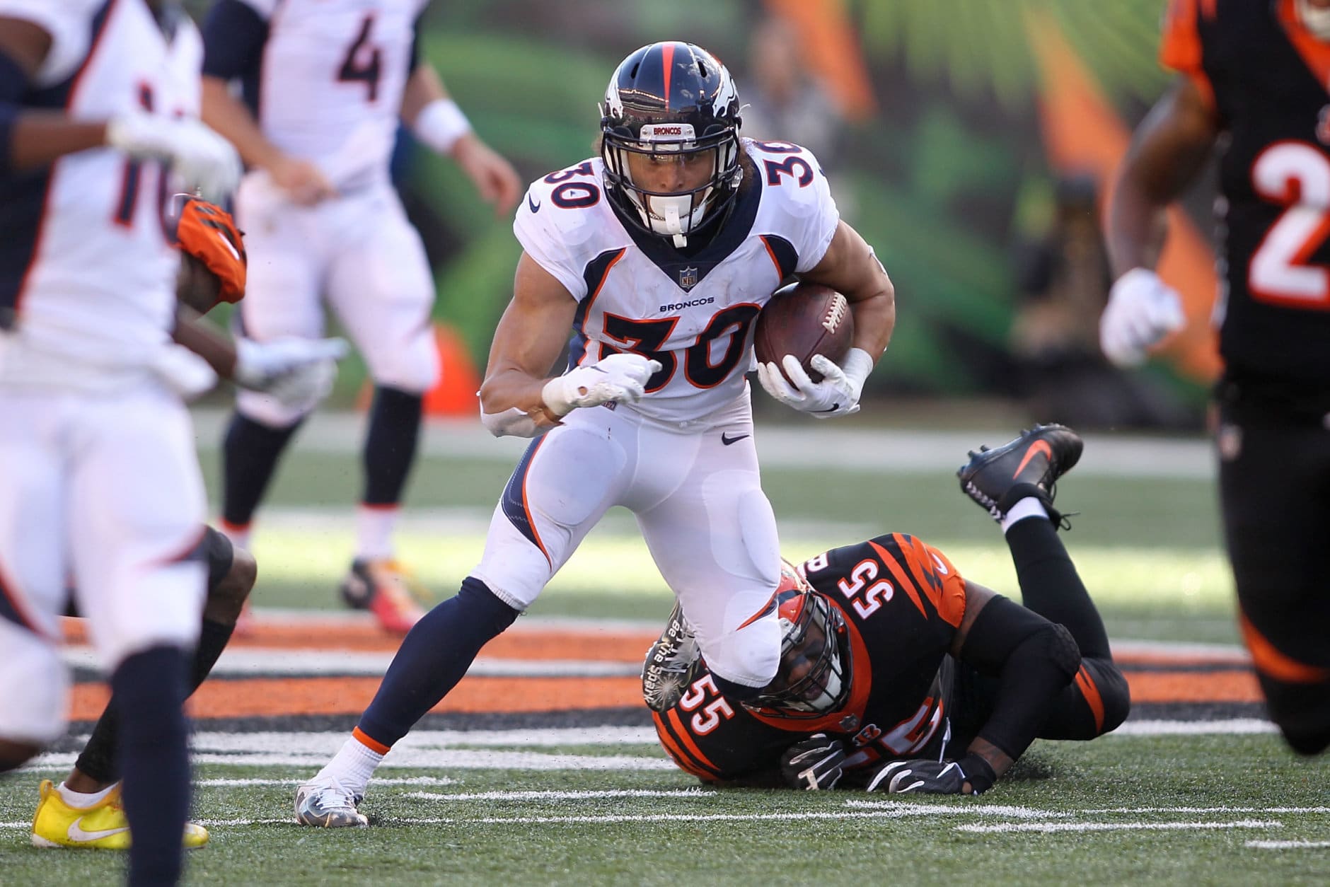 CINCINNATI, OH - DECEMBER 2:  Phillip Lindsay #30 of the Denver Broncos slips out of an attempted tackle by Vontaze Burfict #55 of the Cincinnati Bengals during the second quarter at Paul Brown Stadium on December 2, 2018 in Cincinnati, Ohio. (Photo by John Grieshop/Getty Images)