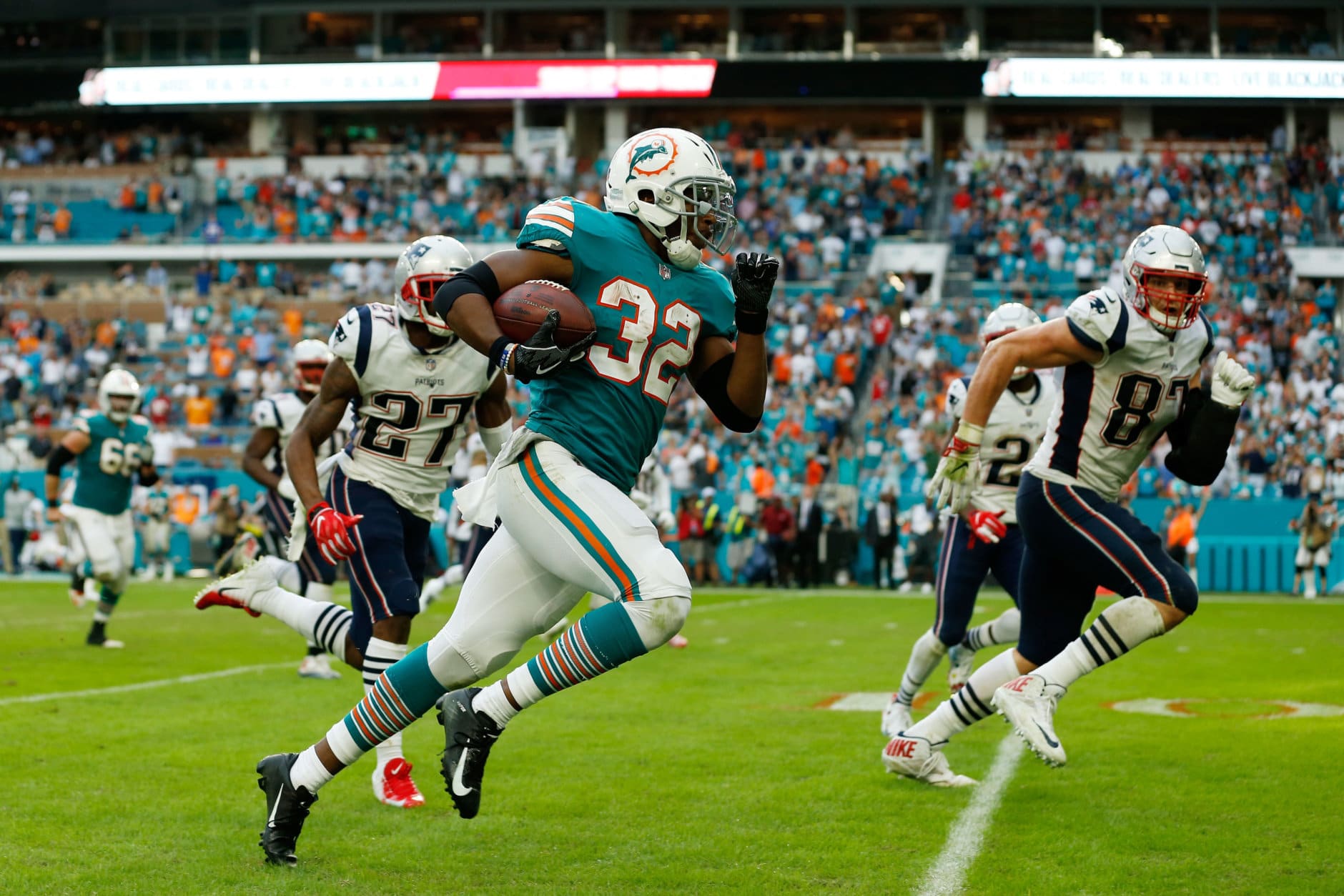 MIAMI, FL - DECEMBER 09: Kenyan Drake #32 of the Miami Dolphins carries the ball for the game winning touchdown during the fourth quarter against the New England Patriots at Hard Rock Stadium on December 9, 2018 in Miami, Florida.  (Photo by Michael Reaves/Getty Images)