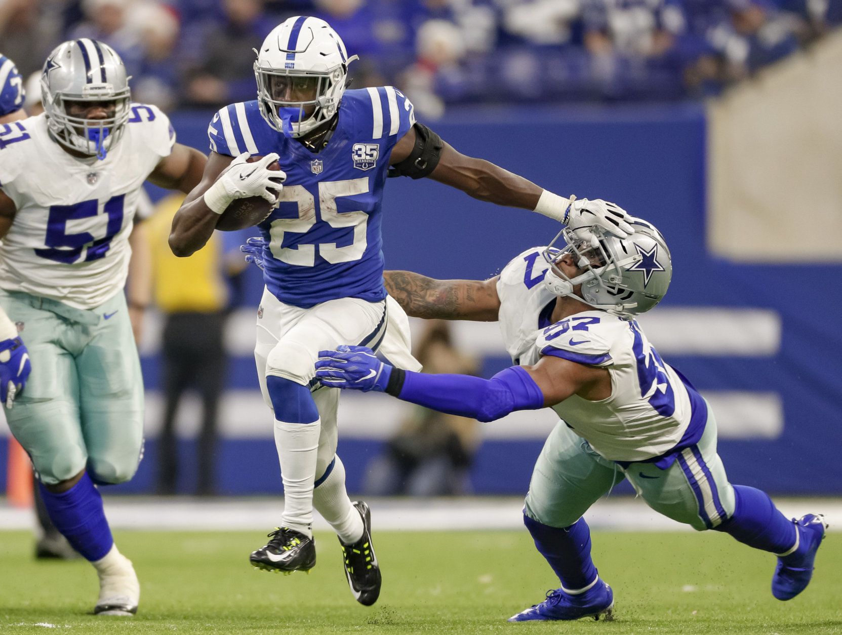 INDIANAPOLIS, IN - DECEMBER 16: Marlon Mack #25 of the Indianapolis Colts puts the stiff arm to Damien Wilson #57 of the Dallas Cowboys during the game at Lucas Oil Stadium on December 16, 2018 in Indianapolis, Indiana. (Photo by Michael Hickey/Getty Images)