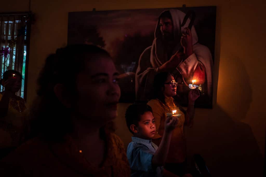 BANTEN, INDONESIA - DECEMBER 25: Christians hold candles during Christmas Eve mass at a church on December 25, 2018 in Carita, Banten province, Indonesia. At least 429 people have reportedly been killed after a volcano-triggered tsunami hit the coast around Indonesia's Sunda Strait on Saturday night, as 150 people remain missing and over 16,000 displaced.  (Photo by Ulet Ifansasti/Getty Images)