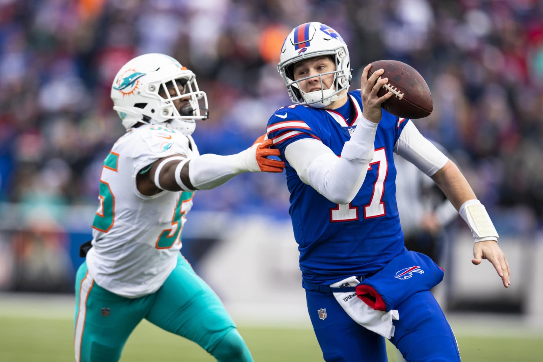 ORCHARD PARK, NY - DECEMBER 30:  Josh Allen #17 of the Buffalo Bills runs with the ball as he tries to avoid Jerome Baker #55 of the Miami Dolphins during the third quarter at New Era Field on December 30, 2018 in Orchard Park, New York. Buffalo defeats Miami 42-17. (Photo by Brett Carlsen/Getty Images)