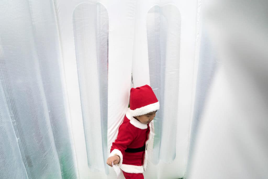 TOKYO, JAPAN - DECEMBER 23:  A child wearing a Santa Claus costume exits a rest area during the Tokyo Great Santa Run 2018 on December 23, 2018 in Tokyo, Japan. About 5,000 people took part in the charity run event held in Tokyo for the first time where part of the participation fee goes into Christmas presents for children who have been hospitalized. (Photo by Tomohiro Ohsumi/Getty Images)