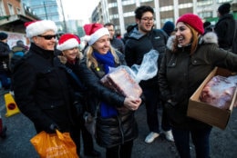 LONDON, ENGLAND - DECEMBER 24: People hold joints of meat they purchased during the annual Harts' Christmas Meat Auction at Smithfield Market on December 24, 2018 in London, England. The annual sell-off attracts hundreds of people to Smithfield Market, which this year celebrates its 150th anniversary, as they hope to snap up a bargain cut of meat including Turkey's, Pork, Beef and Lamb joints. (Photo by Jack Taylor/Getty Images)