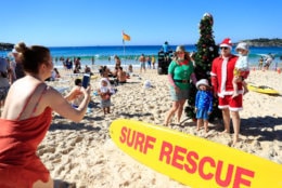 SYDNEY, AUSTRALIA - DECEMBER 25: Families pose by a Christmas tree on Bondi Beach on December 25, 2018 in Sydney, Australia. December is one of the hottest months of the year across Australia, with Christmas Day traditionally involving a trip to the beach and celebrations outdoors. (Photo by Mark Evans/Getty Images)