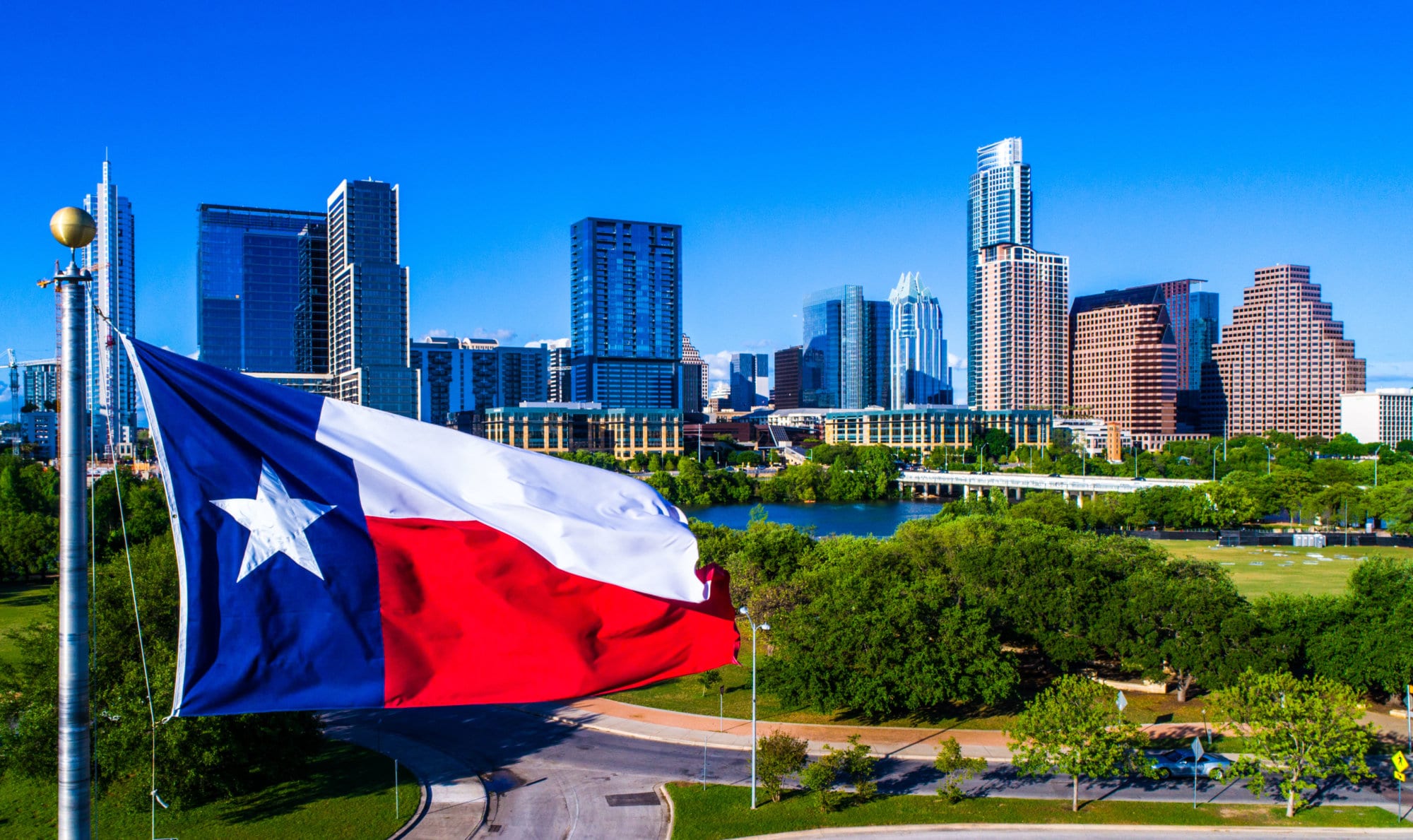 Aerial drone view Austin Texas Perfect Texas flag flying in front of Austin Texas downtown skyline cityscape sunny perfect day