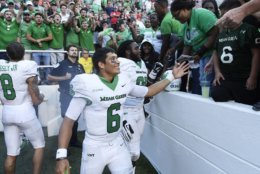 North Texas quarterback Mason Fine celebrates with fans after defeating Arkansas 44-17 after an NCAA college football game Saturday, Sept. 15, 2018, in Fayetteville, Ark. (AP Photo/Michael Woods)