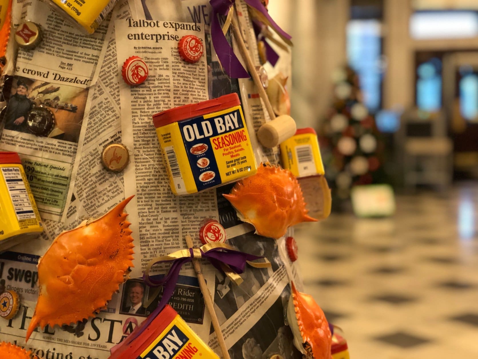 photo of a tree decorated with Old Bay tins, crabs and newspaper