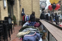 Volunteers collect and organize donated coats at Bin 1301 Wine Bar on U Street. (WTOP/Melissa Howell)