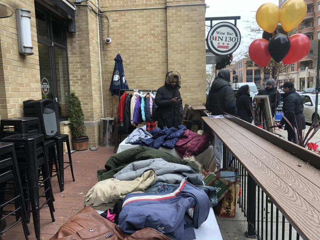 Volunteers collect and organize donated coats at Bin 1301 Wine Bar on U Street. (WTOP/Melissa Howell)