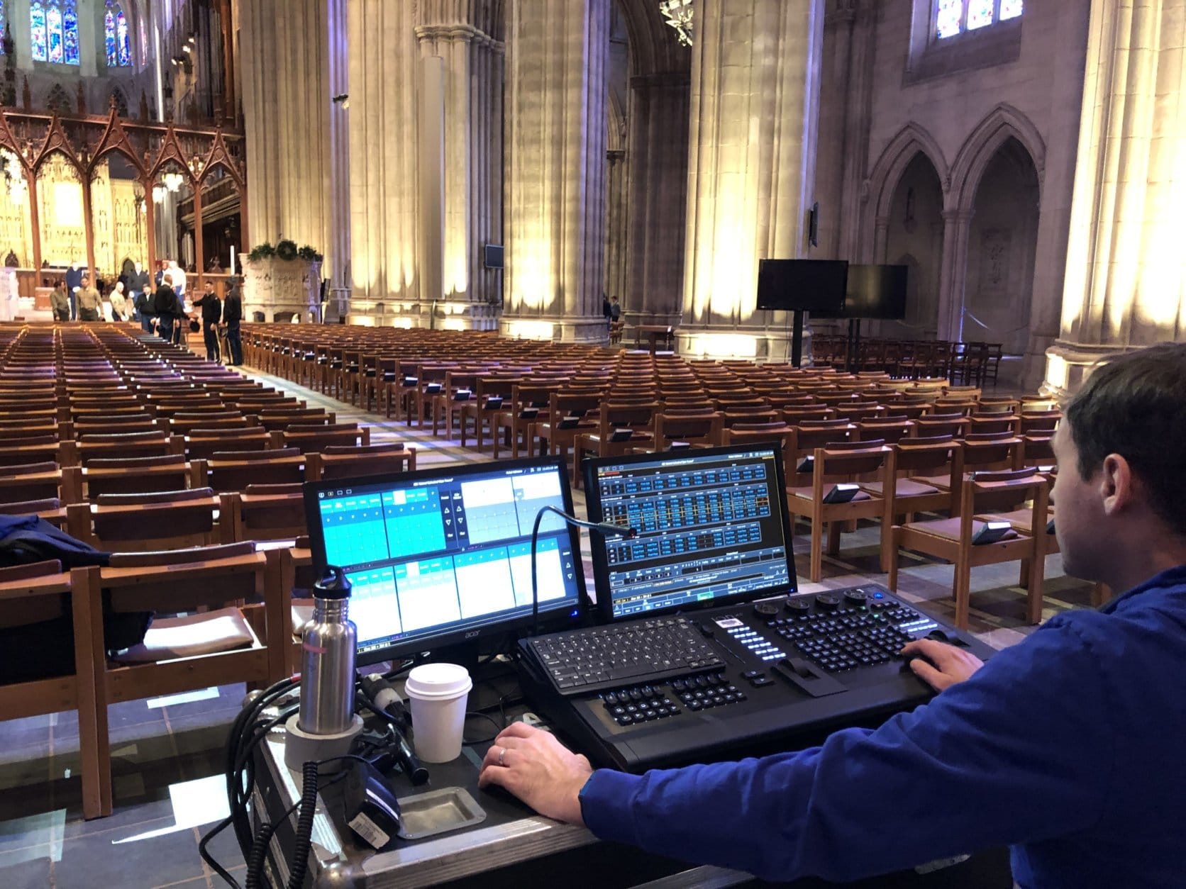 Technicians sat in front of panels tweaking adjustments on keyboards that would shape countless elements of what viewers will see and hear during Wednesday's service along the aisles, pews and alter, which was labeled as "stage." (WTOP/Kristi King)