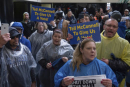 Furloughed government workers protest the government shutdown at the door of U.S. Sen. Mitch McConnell's office in Lexington, Ky., Wednesday, Jan 23, 2019. (AP Photo/Bryan Woolston)