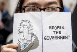 A furloughed government worker affected by the shutdown holds a sign that reads "Reopen the Government" during a silent protest against the ongoing partial government shutdown on Capitol Hill in Washington, Wednesday, Jan. 23, 2019. (AP Photo/Andrew Harnik)